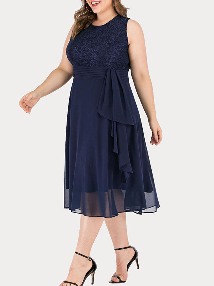 Side view of a woman wearing a navy blue A-line dress with a lace top and chiffon skirt