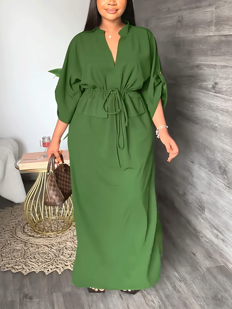 Woman wearing a green V-neck maxi dress with a drawstring waist and side slits.
