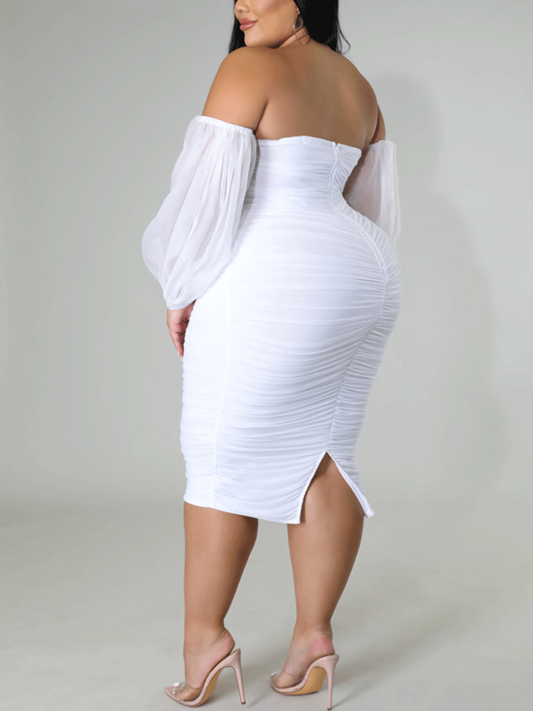Back view of a woman in a white off-the-shoulder ruched midi dress with sheer puff sleeves.