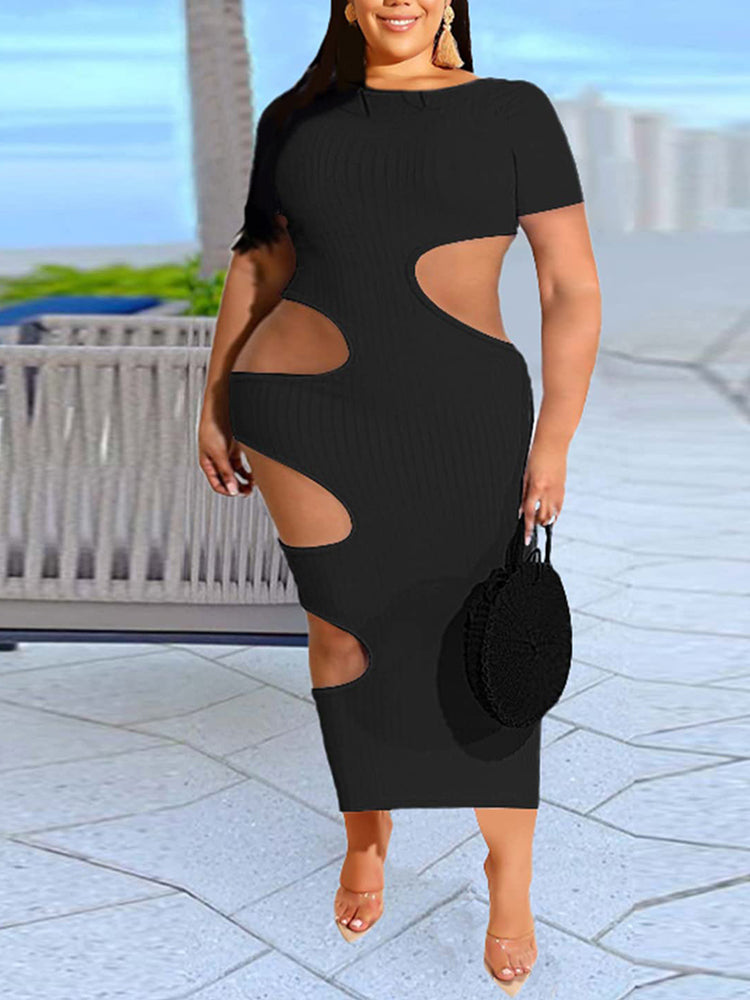 Woman wearing a black midi dress with cut-out details on the sides and a ribbed texture.