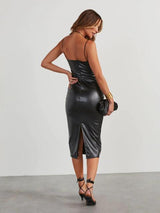 back view of a woman in a black faux leather midi dress with a slit
