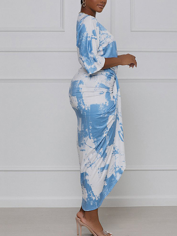 Side view of a woman in a blue and white tie-dye print wrap dress.