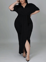 Woman posing in a black wrap dress with draped detailing