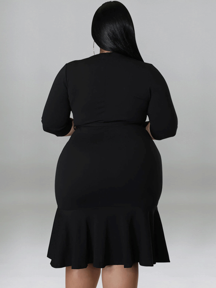 Back view of a plus-size model wearing a black wrap dress with a ruffle hem and three-quarter sleeves.