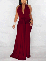 Woman wearing a long burgundy halter dress with a deep V-neckline and ruched waist