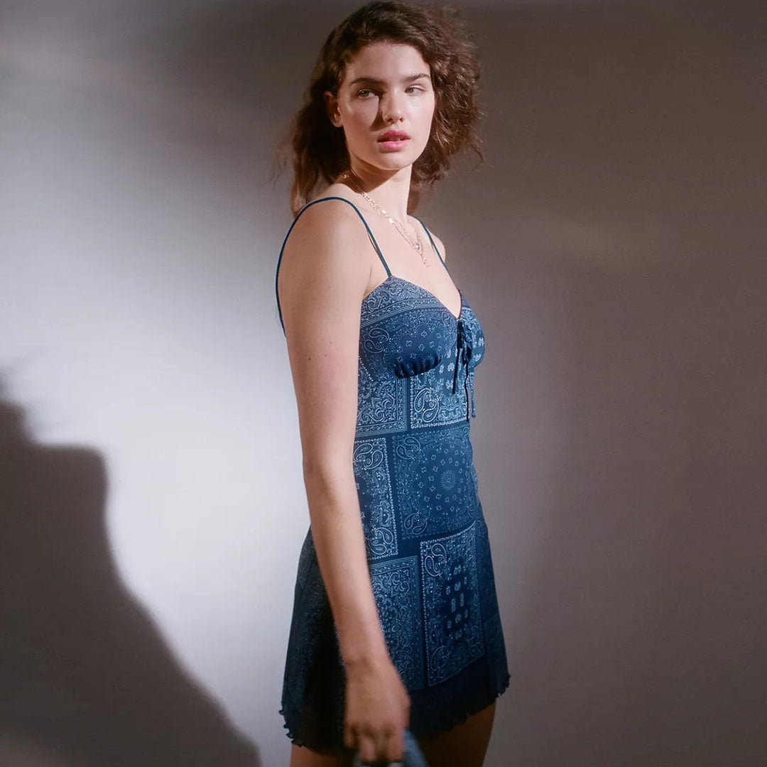 Side view of a model in a blue bandana print mini dress.