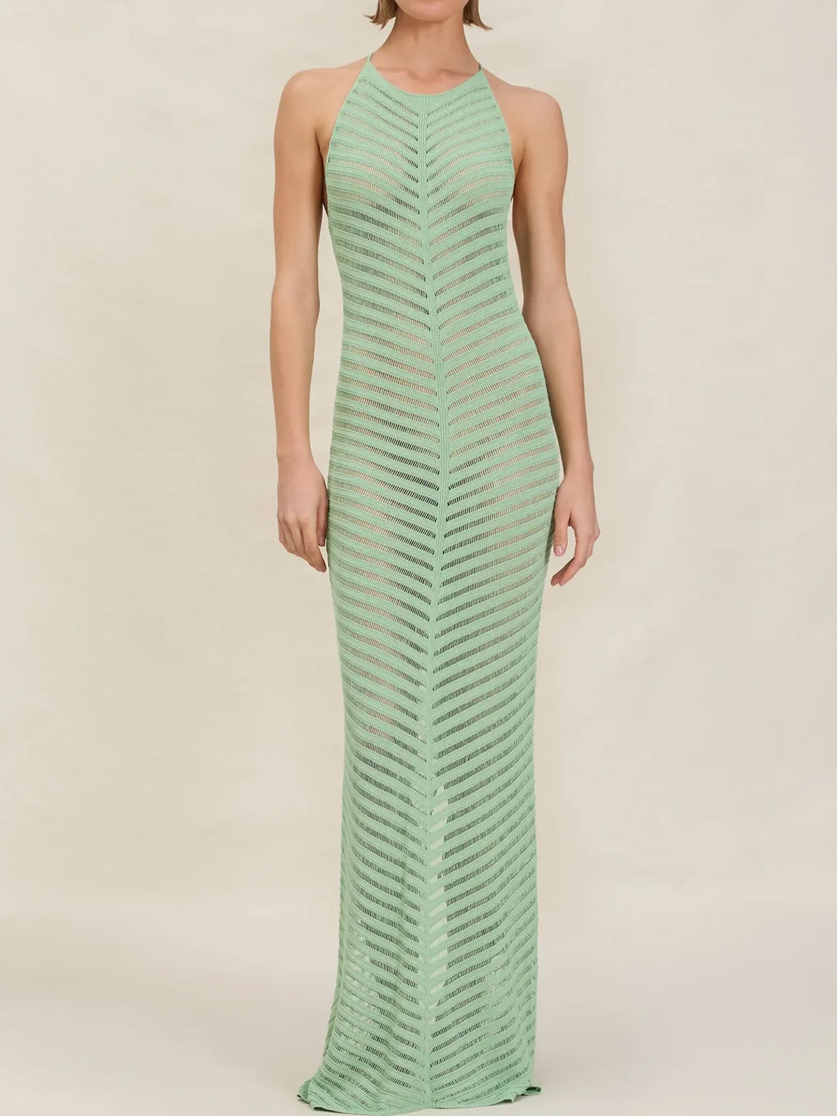 Woman wearing a mint green chevron knit maxi dress with a halter neckline