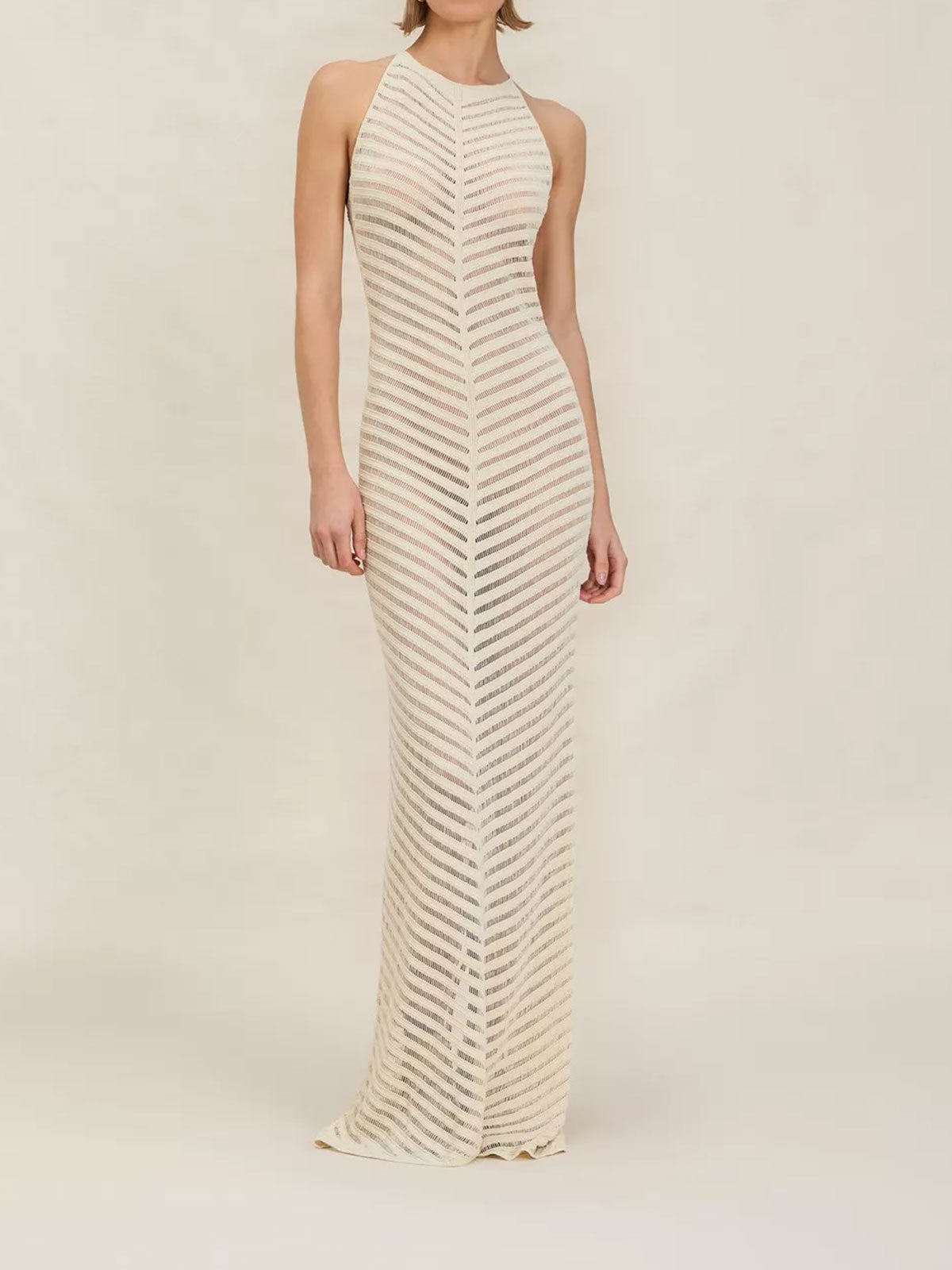 Woman wearing an ivory chevron knit maxi dress with a halter neckline