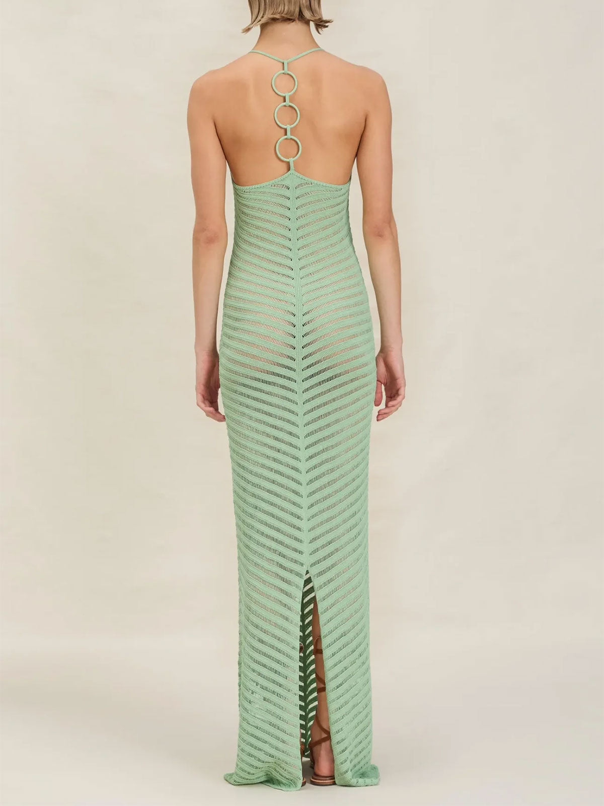 Back view of a woman wearing a mint green chevron knit maxi dress with an open back and ring detail