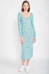 Woman wearing a long-sleeved, scoop-neck, midi-length, bodycon dress with a striped pattern in shades of blue and grey, paired with white sneakers and a gold necklace.
