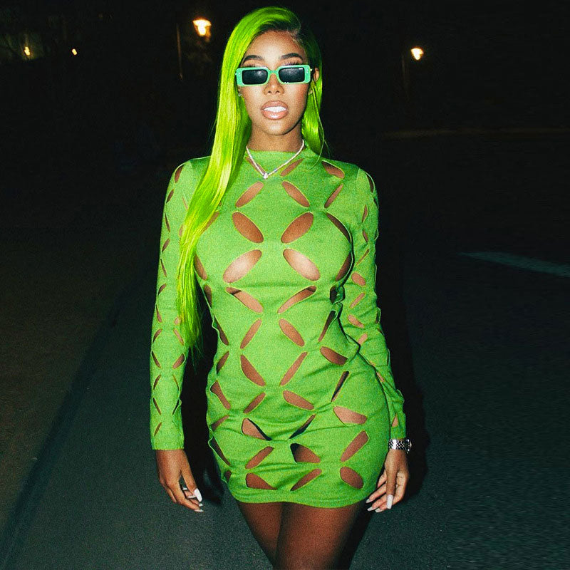 Woman wearing a green long-sleeved mini dress with cut-out details and green sunglasses