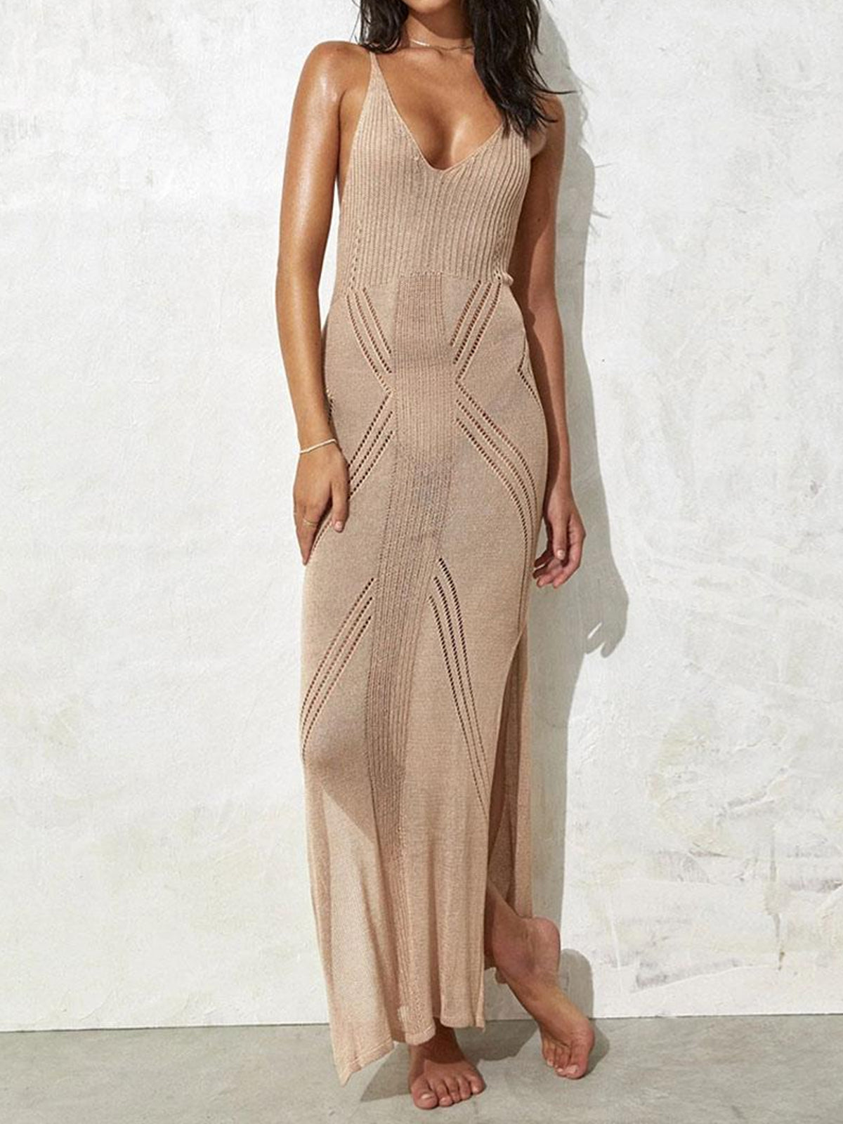 Woman wearing a beige knit maxi dress with open knit detailing and a high slit
