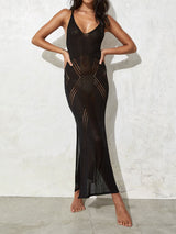 Woman wearing a black knit maxi dress with open knit detailing and a high slit