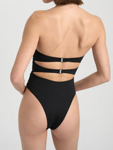 Side view of a black strapless one-piece swimsuit with cut-out details and floral embellishments.
