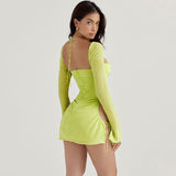 Woman wearing a lime green sheer mini dress with halter neckline and long bell sleeves, back view