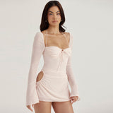 Front view of a woman in a light pink mini dress with a sweetheart bodice and halter neckline.