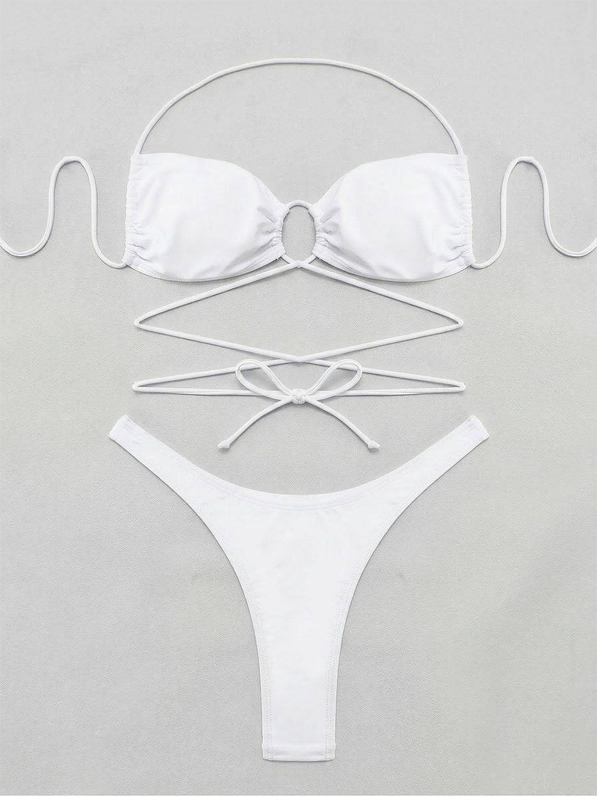 Flat lay of a white strappy bikini top and bottoms