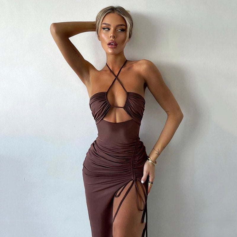 Woman wearing a brown ruched halter neck maxi dress with a high slit.