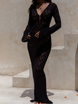 Woman wearing a long-sleeved black knit dress with a diamond pattern and V-neck.