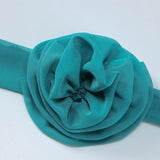 Detailed view of a teal fabric flower with layered petals.