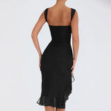 Detail of the ruffled hem on a black mesh dress.