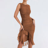 Woman wearing a brown sheer mesh ruched dress with a ruffled asymmetrical hemline, posing from the front.
