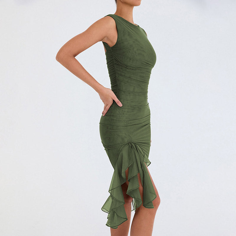 Model wearing a green sleeveless ruched mesh dress with a ruffled asymmetrical hem, side view.
