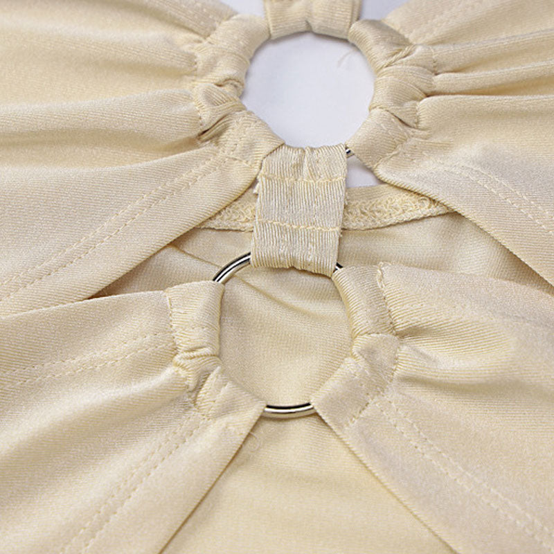 close-up of the halter neckline with ring embellishments on a light beige garment