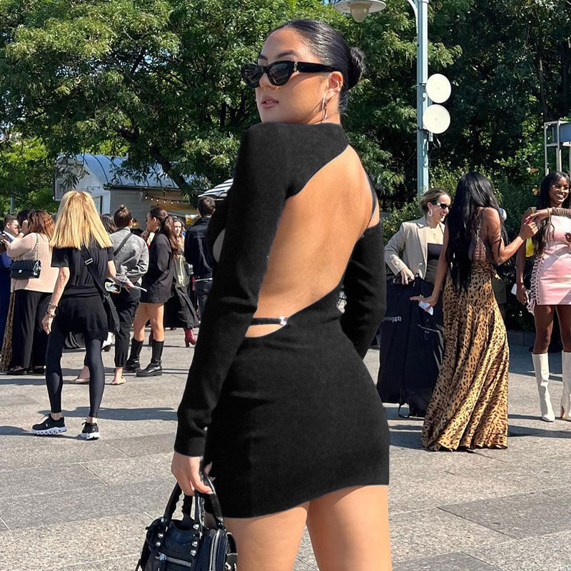 woman in a black long-sleeve open-back mini dress with cut-out details