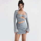 Model wearing a grey long-sleeved ruched mini dress with cut-out details.