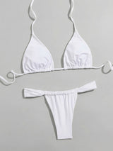 Flat lay of a white triangle bikini top and thong bottom