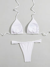 Flat lay of the back of a white triangle bikini top and thong bottom