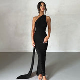 full body shot of a woman in a black fitted maxi dress with a single shoulder strap and flowing train