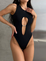 Woman wearing a black one-piece swimsuit with a front cut-out and embellishment