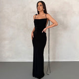 woman wearing a long black dress with tie straps and a cowl neck
