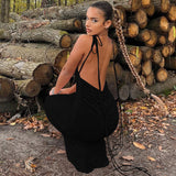 woman in a long black ruched dress with tie straps in an outdoor setting