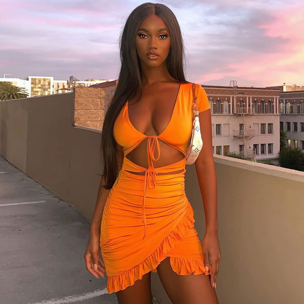 Woman in an orange ruched mini dress with cut-outs and a tie-front
