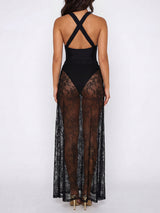 Woman wearing a black maxi dress with a sheer lace overlay and criss-cross back straps, back view.