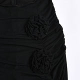 Close-up of the black mesh skirt showing ruched detailing and floral embellishments.