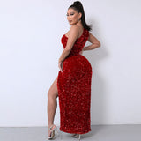 Back view of a woman in a red sequined one-shoulder maxi dress with a high slit.