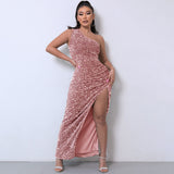 Full-length view of a woman in a rose gold sequined one-shoulder maxi dress with a high slit.
