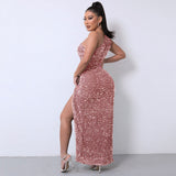 Side profile of a woman showcasing the back of a rose gold sequined one-shoulder maxi dress with a high slit.