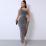 Full-length view of a woman in a sparkling grey sequined dress with a thigh-high slit.