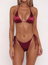 Model wearing a burgundy satin triangle bikini set with adjustable ties