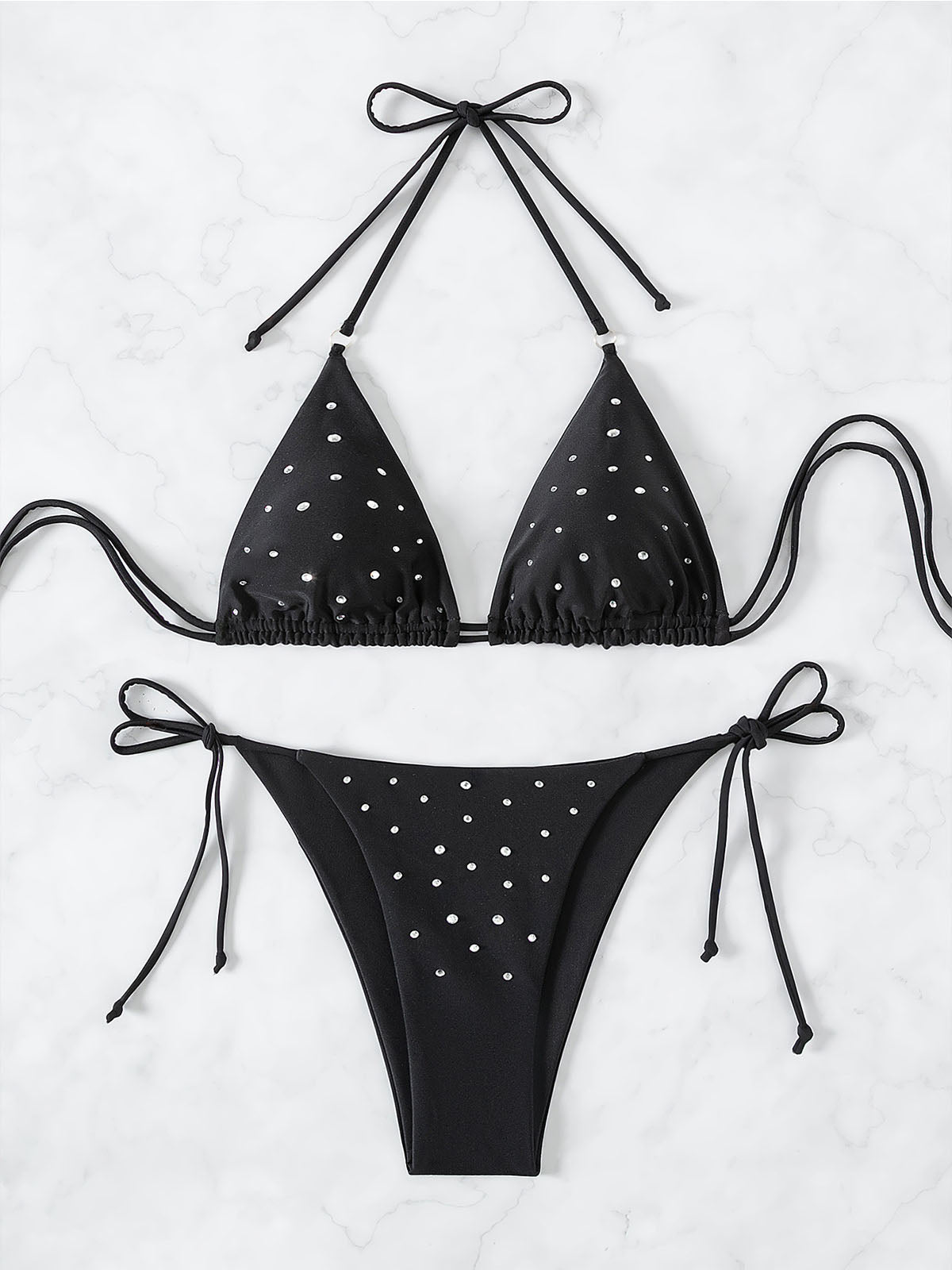 Black bikini top and bottom with sparkle embellishments laid flat