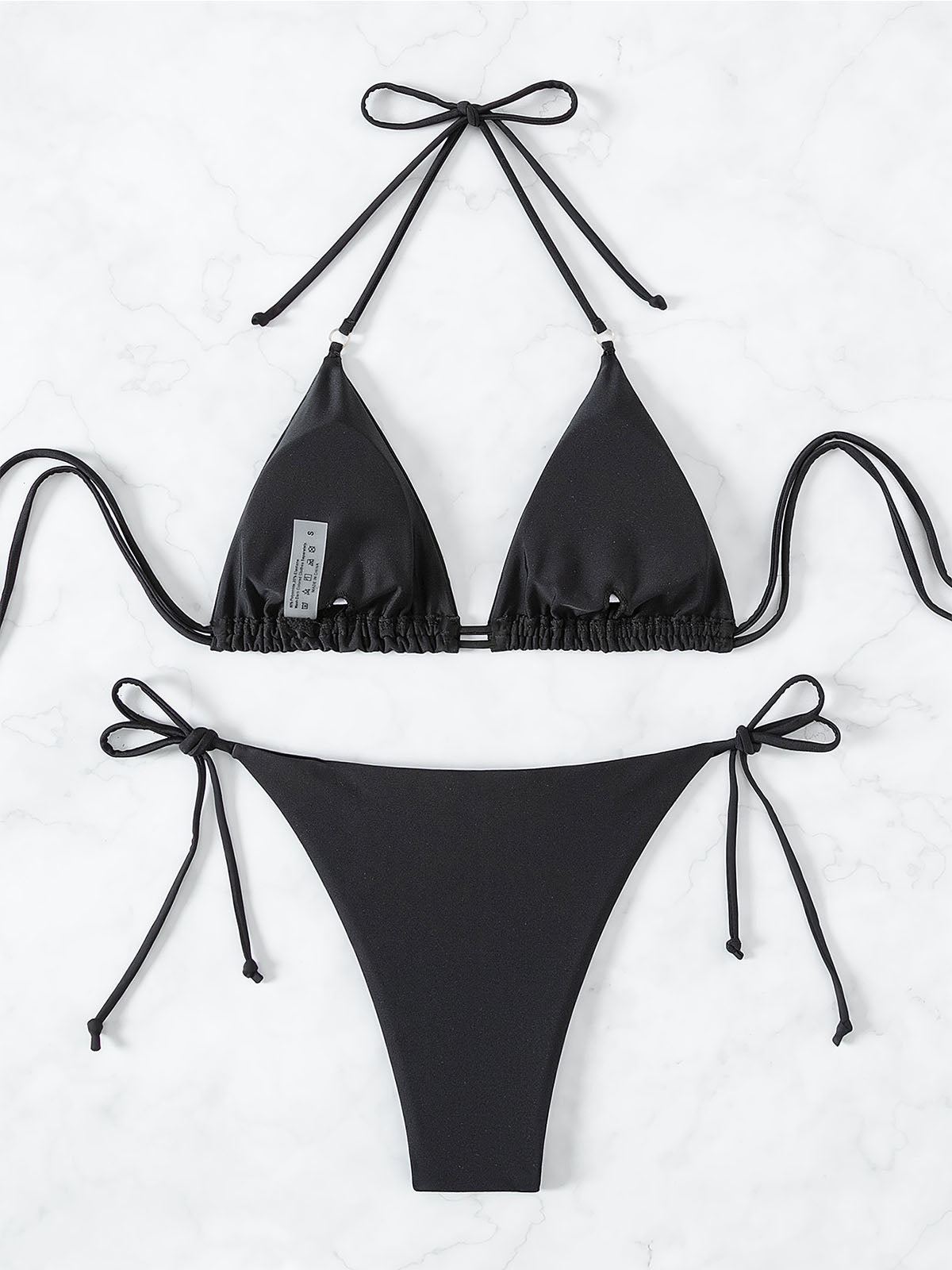 Inside view of a black bikini top and bottom laid flat