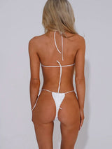Woman wearing a white textured bikini with pearl embellishments, back view.