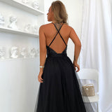 Side view of a woman in a black evening gown showcasing the high slit