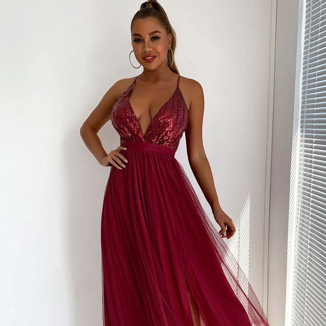 Close-up of a woman in a deep red formal dress, showing the sequined bodice and plunging neckline.