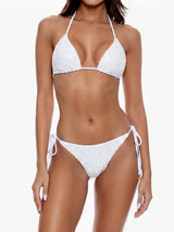 Woman wearing a white sequined bikini against a white background